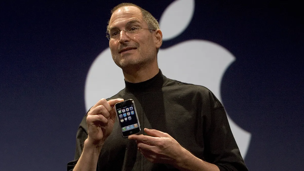 Steve Jobs holding the iPhone